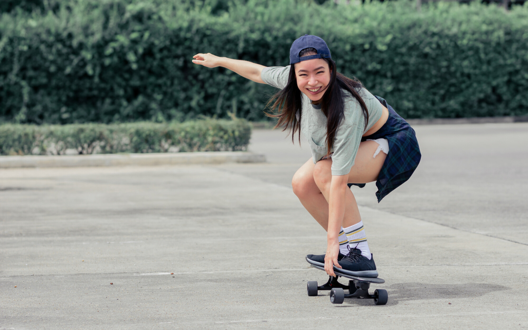 一名女子笑著滑滑板，展現出選擇自己喜愛的運動能盡情享受當中樂趣。
