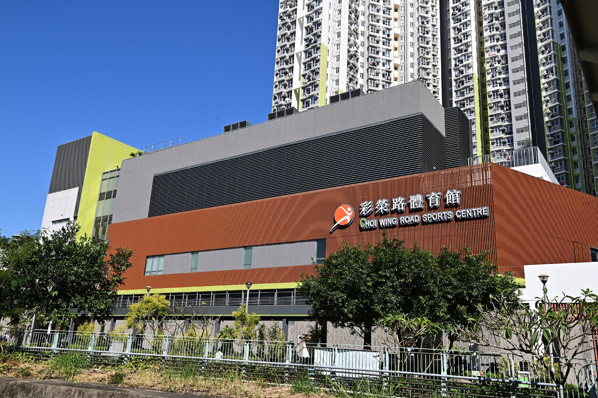  彩榮路體育館外觀，建築採用現代化啡色木紋設計，是九龍區新淨的室內跑步地點。