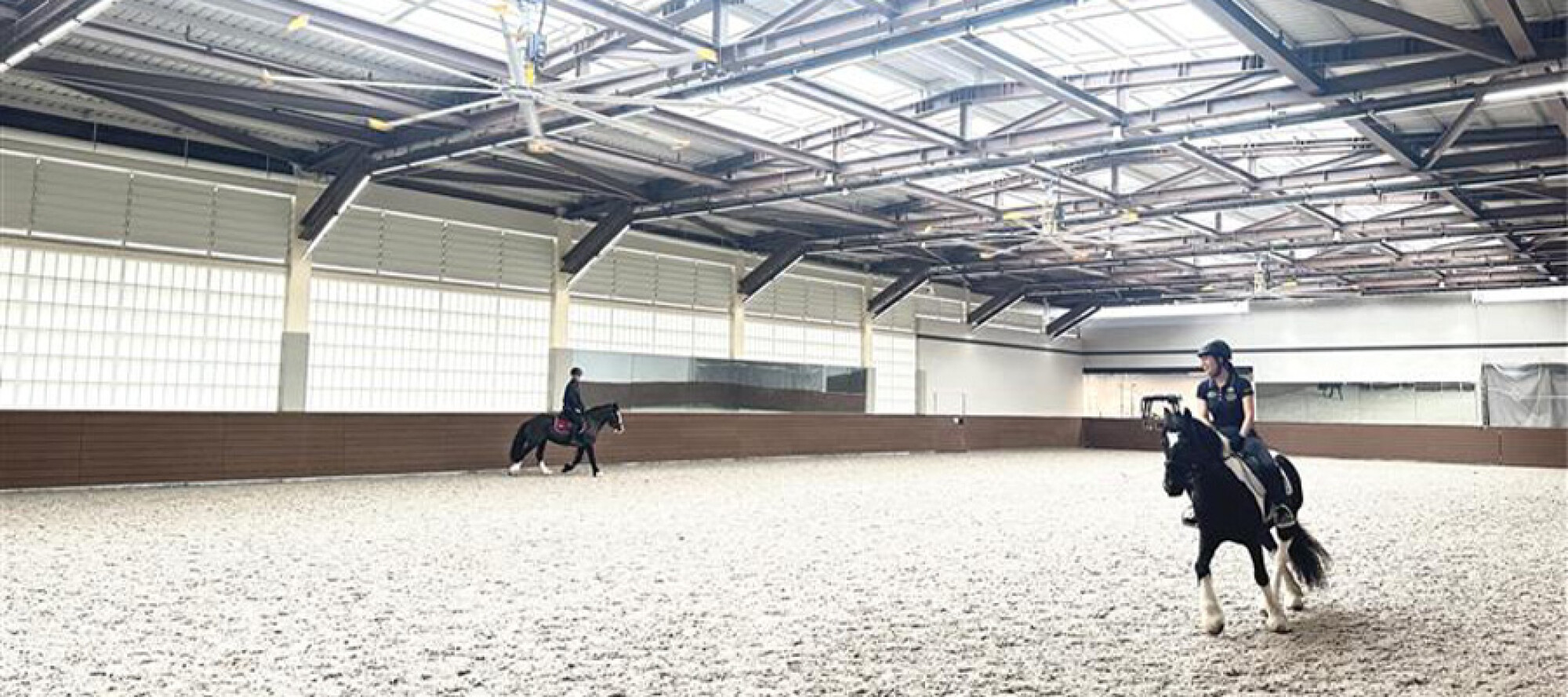 薄扶林公眾騎術學校提供室內沙圈，騎手正在進行馬術訓練。